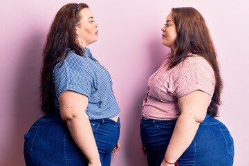 Young plus size twins wearing casual clothes looking to side, relax profile pose with natural face...