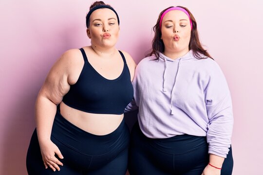Young plus size twins wearing sportswear making fish face with lips, crazy and comical gesture. funny expression.