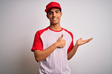 Young handsome african american sportsman wearing striped baseball t-shirt and cap Showing palm hand and doing ok gesture with thumbs up, smiling happy and cheerful