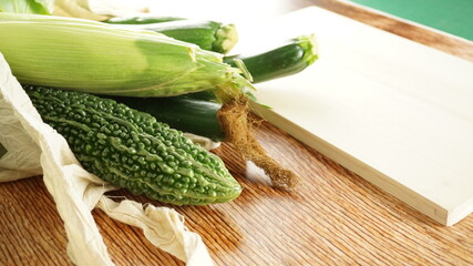 買い物袋から溢れた野菜とまな板