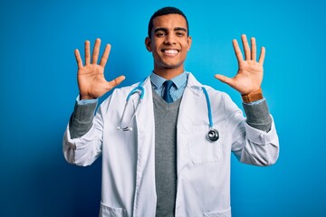 Handsome african american doctor man wearing coat and stethoscope over blue background showing and pointing up with fingers number ten while smiling confident and happy.