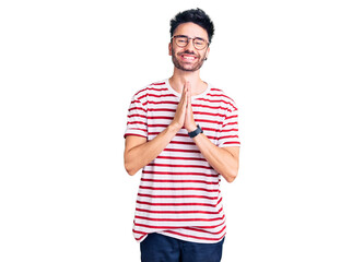 Young hispanic man wearing casual clothes praying with hands together asking for forgiveness...