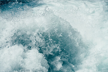 Fototapeta na wymiar Frozen splashing in rapids of powerful mountain river. Surf of clear water close-up. Nature background with tide of azure water. Frozen motion of splashes. Backdrop of only water. Full frame of tide.