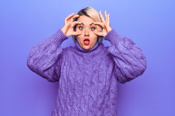 Beautiful blonde plus size woman wearing casual turtleneck sweater over purple background Trying to open eyes with fingers, sleepy and tired for morning fatigue