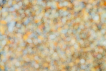 Vivid blurry background with many small bokeh of different colors and shades. Multicolor blur texture of autumn. Colorful bokeh backdrop. Picturesque blurred color mix. Scenic yellow orange abstract.