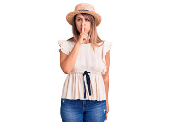 Young beautiful woman wearing summer hat and t-shirt asking to be quiet with finger on lips. silence and secret concept.