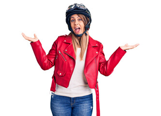 Young beautiful woman wearing motorcycle helmet celebrating victory with happy smile and winner expression with raised hands