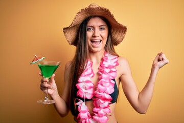 Beautiful woman with blue eyes on vacation wearing bikini and hawaiian lei drinking cocktail...