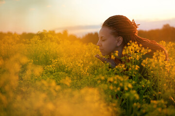 Fototapeta premium red-haired girl in a field of diverse flowers. the concept of freedom, relaxation, enjoyment of the world. and free breathing without allergies