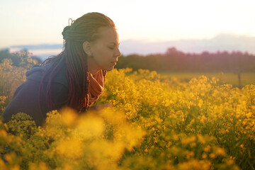Fototapeta premium red-haired girl in a field of diverse flowers. the concept of freedom, relaxation, enjoyment of the world. and free breathing without allergies
