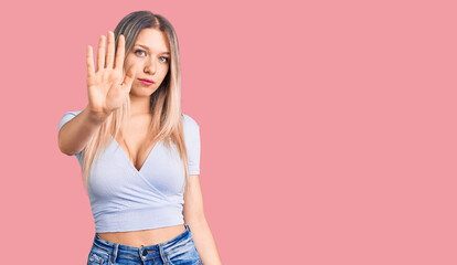 Young beautiful blonde woman wearing casual clothes doing stop sing with palm of the hand. warning expression with negative and serious gesture on the face.