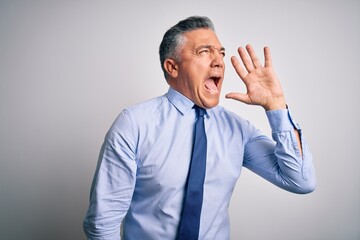 Middle age handsome grey-haired business man wearing elegant shirt and tie shouting and screaming loud to side with hand on mouth. Communication concept.