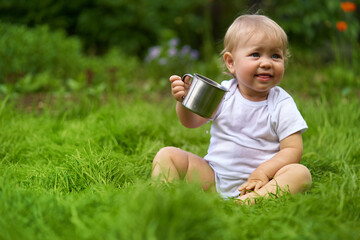 child with a mug of drink outdoors