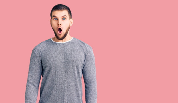 Young handsome man wearing casual sweater afraid and shocked with surprise expression, fear and excited face.