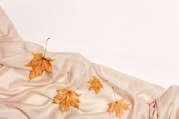 Yellow autumn leaves flat lay on white wooden background with copy space. Natural leaves of maple tree and cozy warm palantine, autumnal theme. Top view.