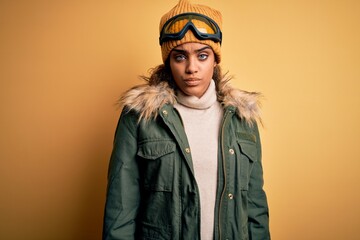 Young african american afro skier girl wearing snow sportswear and ski goggles skeptic and nervous, frowning upset because of problem. Negative person.