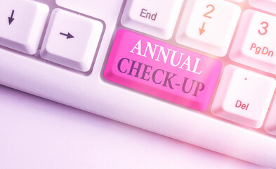 Word writing text Annual Checkup. Business photo showcasing yearly reproductive health visit with a health care provider White pc keyboard with empty note paper above white key copy space