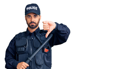 Young hispanic man wearing police uniform holding baton with angry face, negative sign showing...