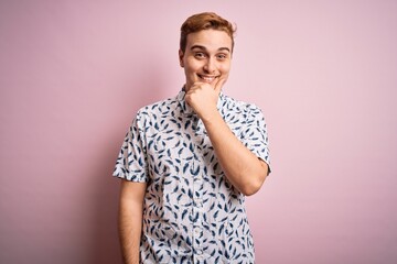 Young handsome redhead man wearing casual summer shirt standing over pink background looking confident at the camera smiling with crossed arms and hand raised on chin. Thinking positive.