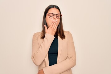 Young beautiful brunette businesswoman wearing jacket and glasses over white background bored yawning tired covering mouth with hand. Restless and sleepiness.