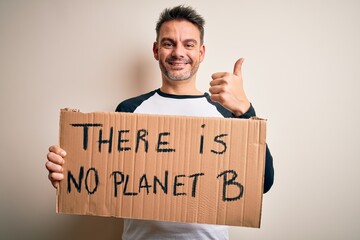 Young handsome man asking for environment holding banner with planet message happy with big smile doing ok sign, thumb up with fingers, excellent sign