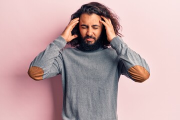 Young arab man wearing casual clothes with hand on head, headache because stress. suffering migraine.