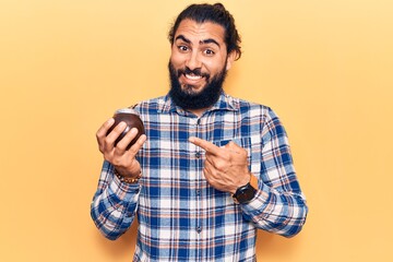 Young arab man drinking mate infusion smiling happy pointing with hand and finger