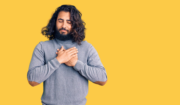 Young arab man wearing casual clothes smiling with hands on chest with closed eyes and grateful gesture on face. health concept.