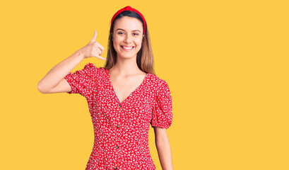 Obraz premium Young beautiful girl wearing dress and diadem smiling doing phone gesture with hand and fingers like talking on the telephone. communicating concepts.