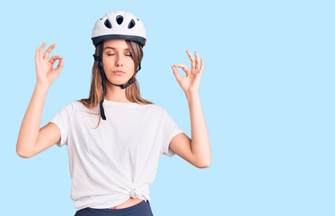 Young beautiful girl wearing bike helmet relax and smiling with eyes closed doing meditation...