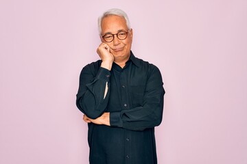 Middle age senior grey-haired handsome man wearing glasses and elegant shirt thinking looking tired and bored with depression problems with crossed arms.