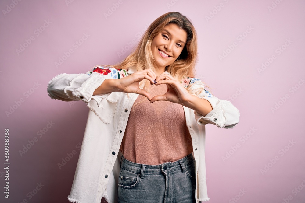 Canvas Prints young beautiful blonde woman wearing casual jacket standing over isolated pink background smiling in