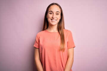 Young beautiful woman wearing casual t-shirt standing over isolated pink background with a happy and cool smile on face. Lucky person.