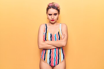 Young beautiful blonde woman wearing swimwear skeptic and nervous, disapproving expression on face...