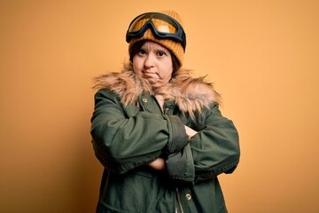 Young down syndrome woman wearing ski coat and glasses for winter weather skeptic and nervous, disapproving expression on face with crossed arms. Negative person.