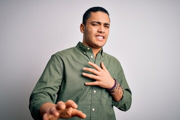 Young brazilian man wearing casual shirt standing over isolated white background disgusted...