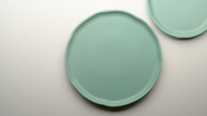 Mock-up turquoise ceramic plates and copy space on white dinning table