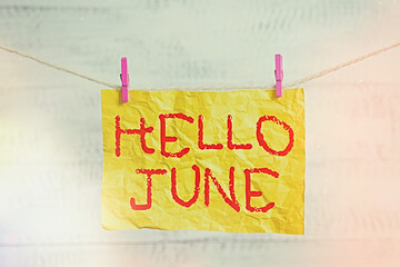 Word writing text Hello June. Business photo showcasing a new month to plan your activities for fun and adventures Clothesline clothespin rectangle shaped paper reminder white wood desk