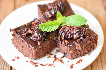 Cake chocolate delicious dessert served on the table - cake slice on white plate with topping chocolate and mint leaf
