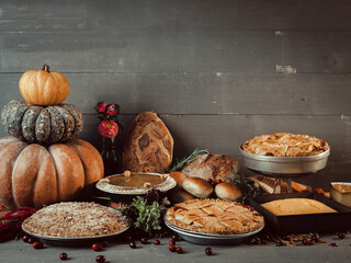 Arrangement of Fall season desserts on wooden farm table with pumpkins and decor