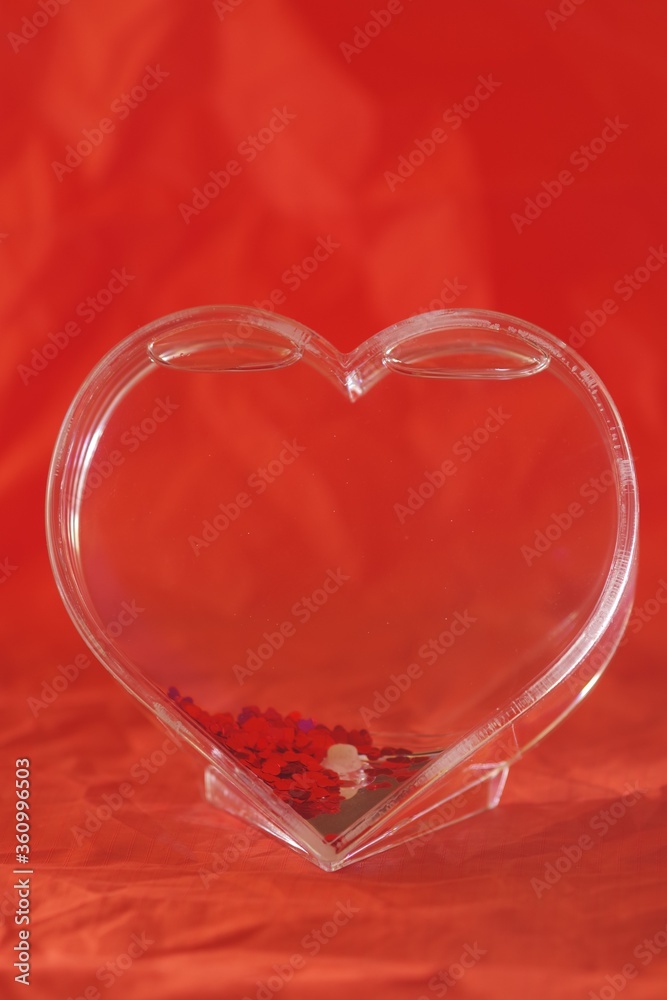 Poster Vertical shot of a heart on a red background