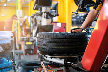 car automobile mechanic working on repairing the wheel tire of vehicle, taking car in for service workshop for male car mechanic fixing problems replacing broken parts of using tools and equipment