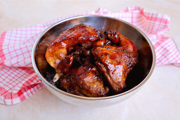 Homemade Kalasan Grilled Chicken (Ayam Bakar) with red table cloth front view, is one of an Indonesian food from Kalasan, Yogyakarta with sweet and savory tastes from black soy sauce