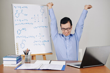 Smiling young teacher stretching after studying online all day long