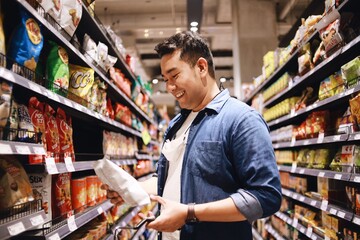 Asian man wearing medical mask shopping in supermarket.