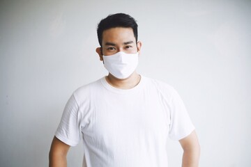 A man in casual shirt wearing medical mask.