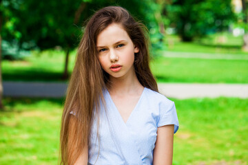 Fototapeta premium Portrait of a young beautiful brunette girl in summer park