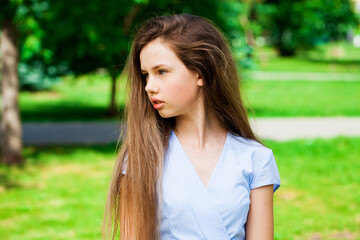 Naklejka premium Portrait of a young beautiful brunette girl in summer park