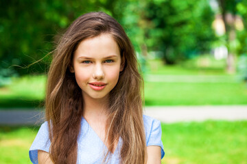 Close up portrait of a young beautiful brunette  girl in summer park