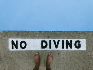 No diving stenciled pooldeck singage.